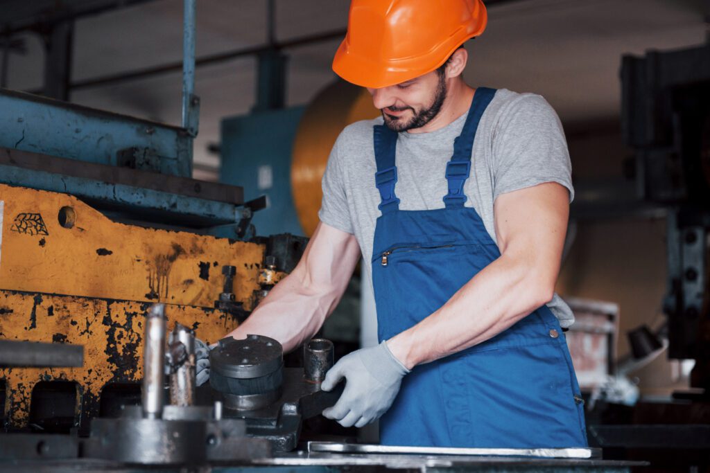 portrait young worker hard hat large metalworking plant